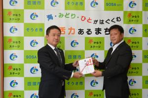寄附贈呈式の写真(左：山本成田支社長、右：宮内市長)